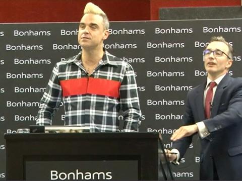 VIDEO : Exclu Vido : Robbie Williams : dans la peau d'un commissaire priseur !