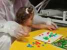 La pequeña Carmela trabaja con su fisioterapeuta para darle más uso a su brazo derecho
