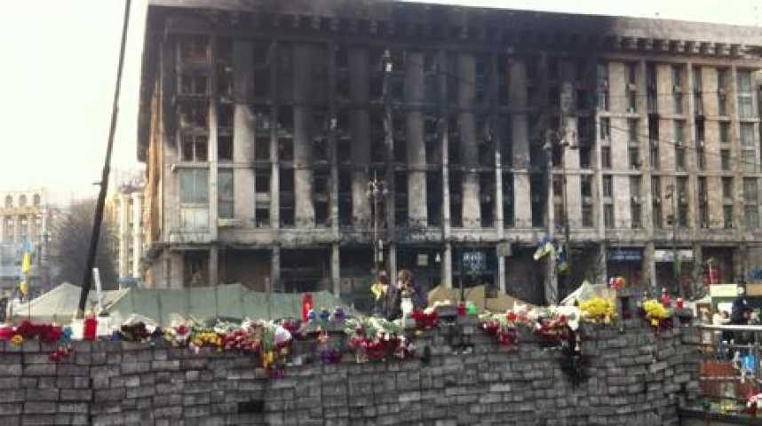 Illustration pour la vidéo Les restes d'un stock de pavés devant l'immeuble QG de la révolution, incendié au cours des combats