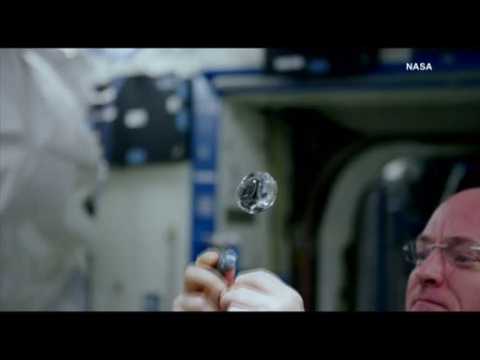 Astronaut dissolves effervescent tablet in sphere of water