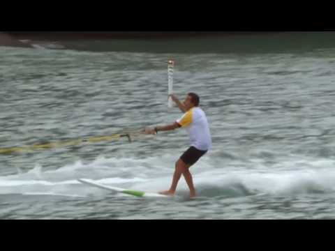 Brazilian surfer rides waves with Olympic torch