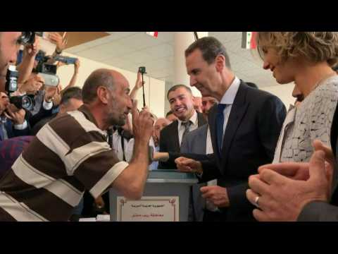 Syrian President Bashar al-Assad and his wife Asma cast their votes in war-torn Douma