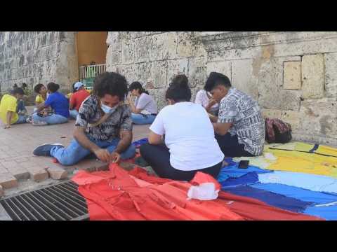 Artists join the strike and weave the Colombian flag with pieces of cloth