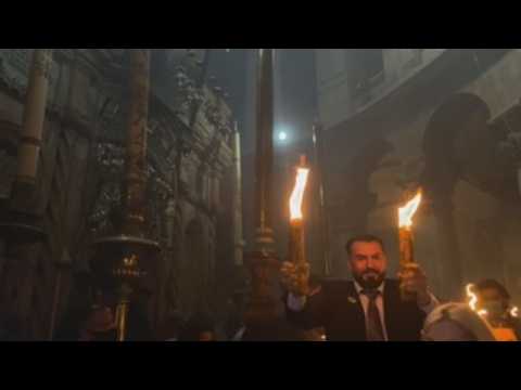 The sacred fire illuminates the Holy Sepulchre of Jerusalem