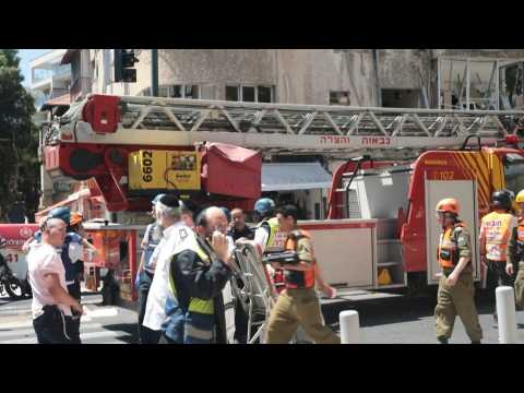 Israeli firefighters at the scene of a rocket explosion in Ramat Gan