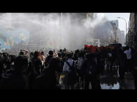 Protesters and riot police clash in Santiago de Chile