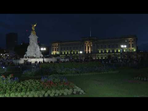 Crowds gather outside Buckingham Palace at night