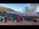 People watch as lava spews out of volcanic fissure in Iceland