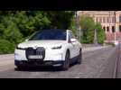 The first-ever BMW iX in White Driving in the city
