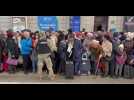 Ukrainiens et étrangers attendent un train à Lviv pour la Pologne