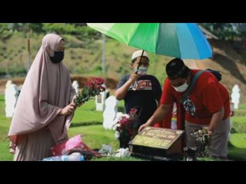 Family members visit their loved ones who died from covid-19 in Indonesia