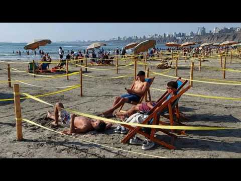 Peruvians enjoy the beach while social distancing in roped off squares
