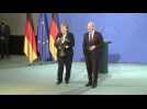 Handover between Angela Merkel and new German chancellor Olaf Scholz