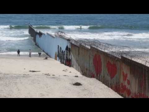 Faces of deported migrants painted on Mexico - US border walls at Mexico's Tijuana beach