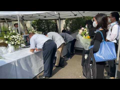 People line up to offer flowers for Abe outside LDP headquarters