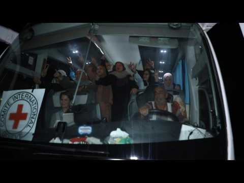 Crowd cheers as an ICRC bus carries prisoners released from Ofer prison in the West Bank