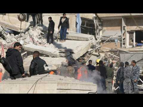 Emergency services clear rubble at the site of strike in Damascus