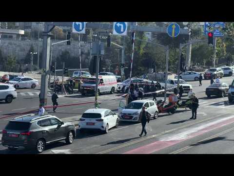 Security forces remove car used during a gun attack on bus stop in Jerusalem