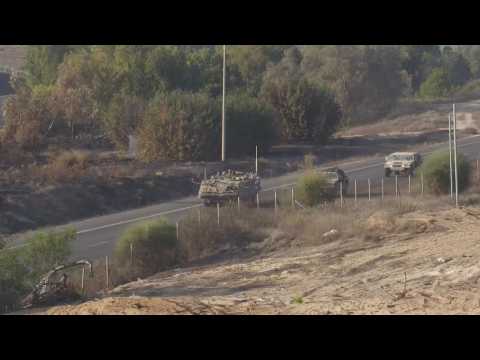 Israeli military vehicles and smoke billowing from northern Gaza Strip