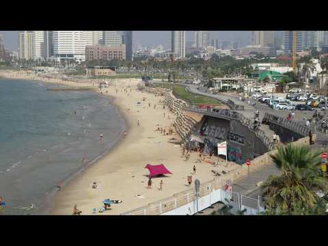 Beachgoers run to take shelter as sirens wail in Tel Aviv