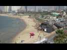 Beachgoers run to take shelter as sirens wail in Tel Aviv