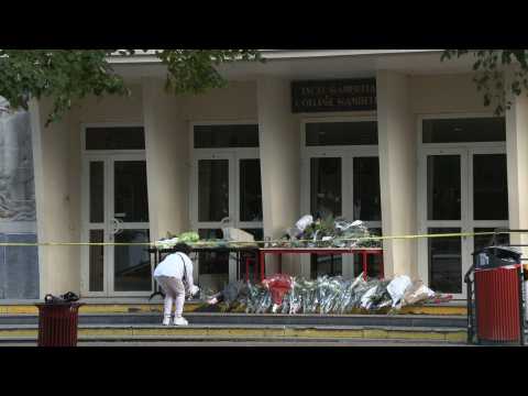 People lay flowers at French school where teacher slain by Islamist