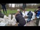 Olivier Véran aide des habitants de La Madelaine-sous-Montreuil a remplir des sacs de sable
