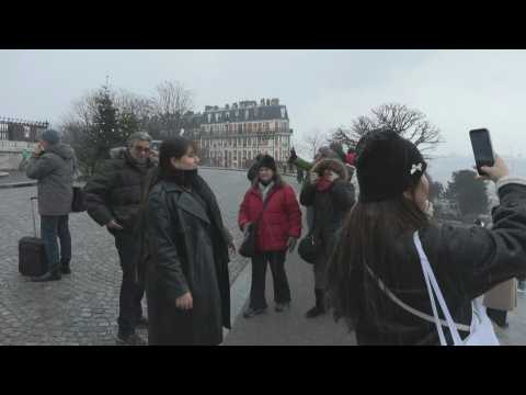 Tourists in light snow outside the Sacre-Coeur Basilica in Paris