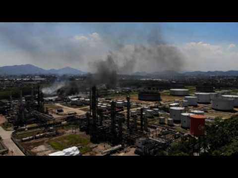 Firemen work to put out fire at Rio oil refinery