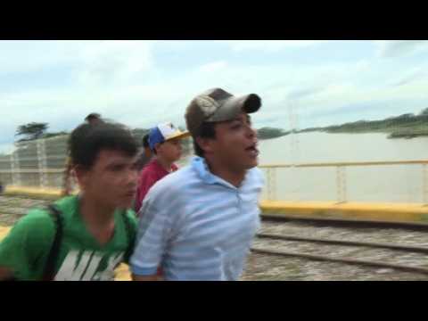 Migrant caravan storms onto bridge to Mexico