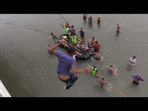 Migrants jump into river from border bridge to reach Mexico