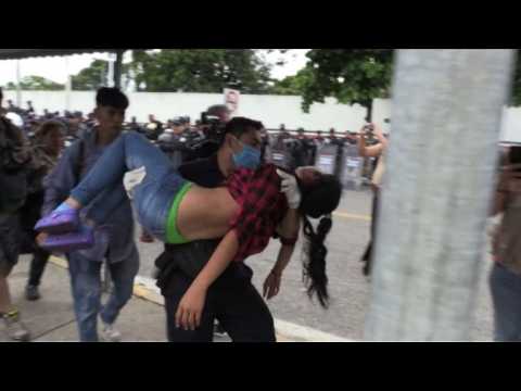Mexican police carries migrants who fainted from border bridge