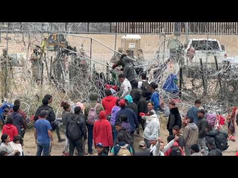 Migrants attempt to pull down section of wire fence on Mexico-US border