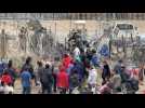 Migrants attempt to pull down section of wire fence on Mexico-US border