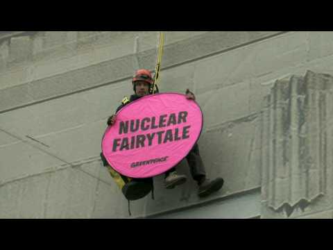 Greenpeace activist hangs from building hosting nuclear summit in Brussels