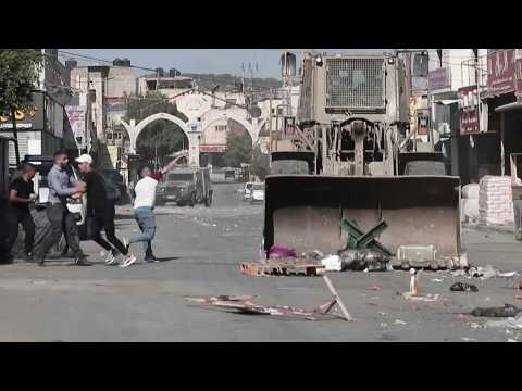 Palestinians throw stones at Israeli bulldozer during raid in WB city