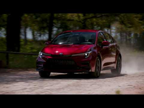 2023 Toyota Corolla SE Hybrid in Ruby Flare Pearl Car Driving in the country