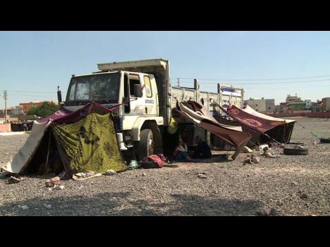 Syrian refugees receive food aid in makeshift Turkish camp