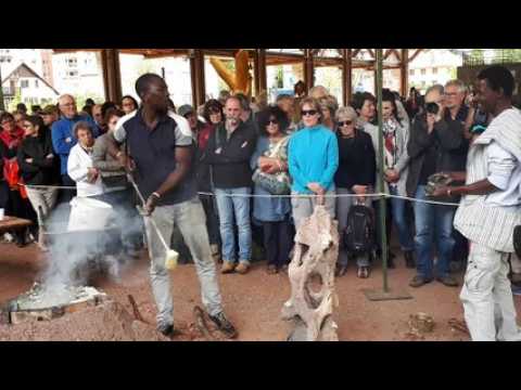 Un sculpteur africain en pleine démonstration de coulage d'une sculpture en bronze