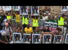 Anti-G7 protesters showcase stolen Macron portraits