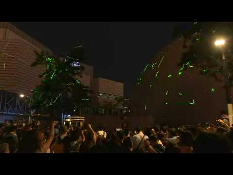 Hong Kong crowds protest student arrest with laser light show