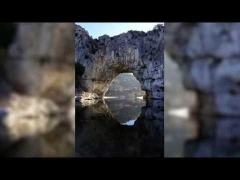 un Haut-Doubien passe sous le Pont d'Arc en paramoteur