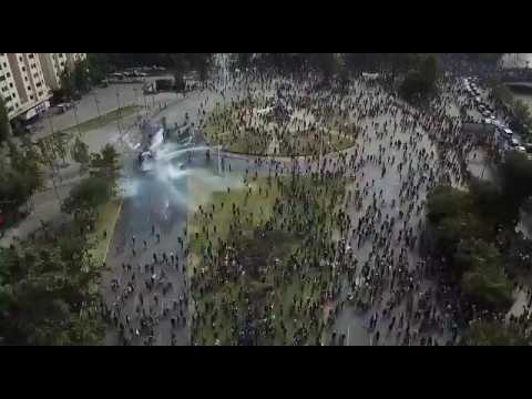 Aerial shots of water cannons spraying crowd of protesters in Santiago