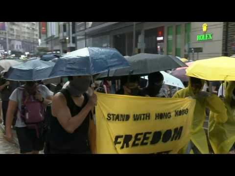 Soaked Hong Kong protesters again defy mask ban in huge rally