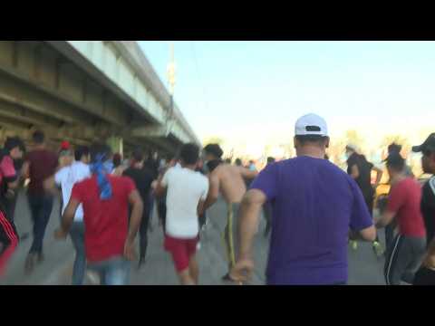 Iraqi protesters run to take cover in the capital Baghdad