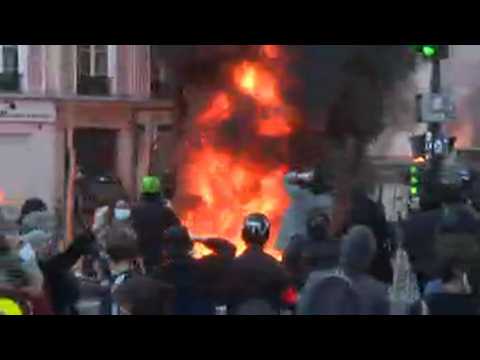 Fires, sounds of explosions as thousands protest new security law in Paris
