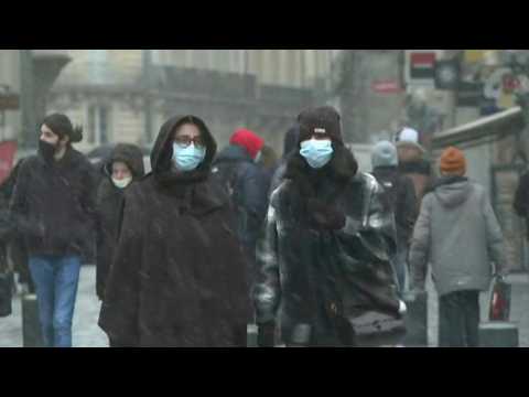 Locals bundle up as snow falls on western France