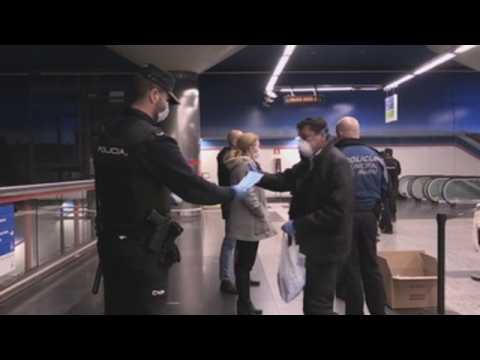 Police hand out masks to those returning to work in Madrid