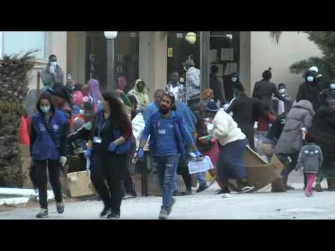 Migrants rush for aid supplies at quarantined Greek hotel