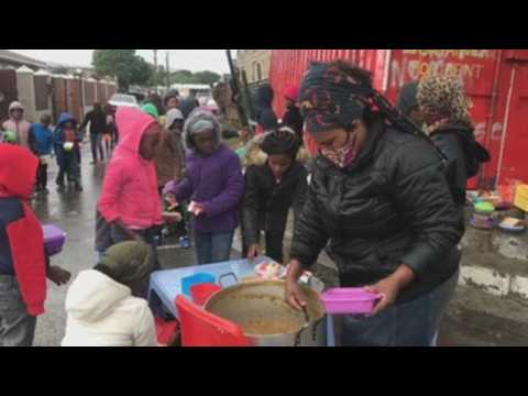 Volunteers distribute food among needy children in Cape Town